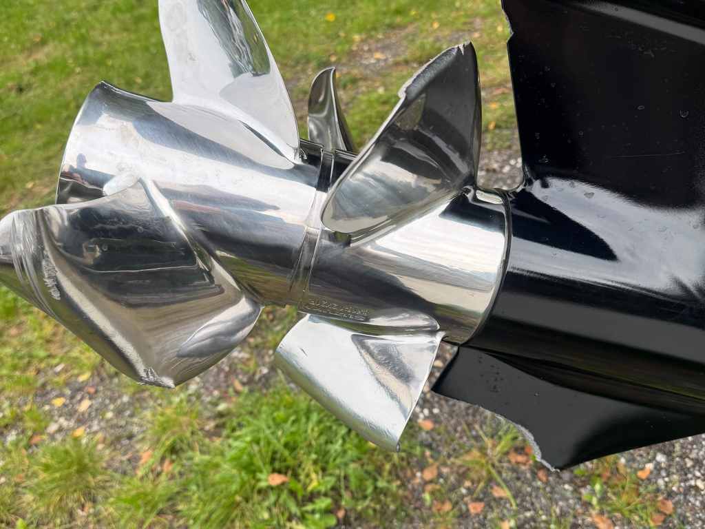 Blankpoleret rustfri propel monteret på et sort drev, fotograferet udenfor over græs og grus